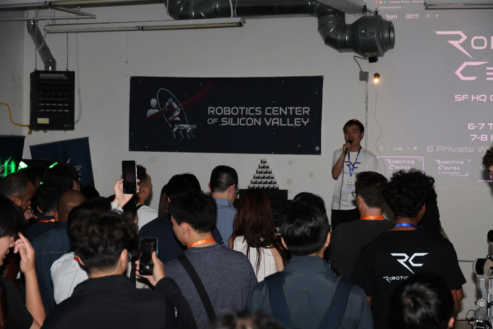 Audience listening to a presentation beneath the Robotics Center of Silicon Valley banner